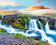 Beautiful scenery with a waterfall Kirkjufell and yellow flowers at dawn in Iceland. Exotic countries. Amazing places. Popular tourist atraction. (Meditation, antistress - concept).
