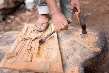 Faceless Man Carving Wood With Chisel