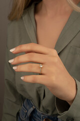 Beautiful lady's hand. woman wearing a white blouse and a diamond ring on her finger.