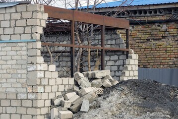 Poster - white broken brick house with a destroyed wall and a brown rusty iron frame on the street