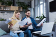 © Liubomir - Happy married couple doing paperwork at home, calculating family budget and paying bills, using laptop, sitting on sofa at home