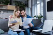 © Liubomir - Man and woman, young family together intently reading a letter, frustrated