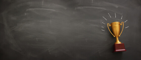 Wall Mural - banner of golden trophy over blackboard background. top view. flat lay.