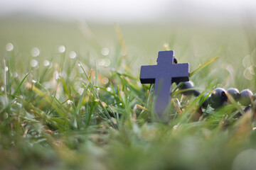 Black rosary on the grass with dew