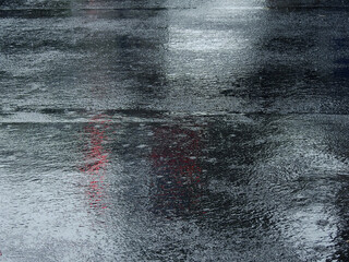 Wall Mural - raindrops falling on wet asphalt road with reflection