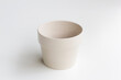 Beige ceramic plant pot isolated on a white background.