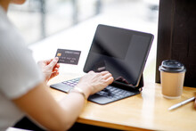 Women Holding Credit Card And Using Tablet Laptop Computer At Coffee Shop.Online Shopping, Internet Banking, Store, Payment, Spending Money, E-commerce Payment At The Store, Credit Card, Concept