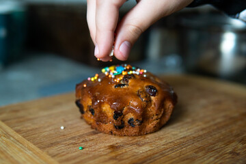 Wall Mural - a child's hand that sprinkles a small beautiful Easter cake