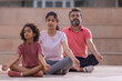 © IndiaPix - Portrait of happy family meditating together at outdoor in the morning