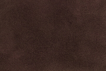 Wall Mural - Background of dark brown suede matte fabric. Velvet matt texture of umber nubuck textile. Velveteen pattern.