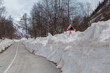 an asphalt road with a lot of snow after winter and an 