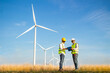 © anusak - engineer team working in wind turbine farm. Renewable energy with wind generator by alternative energy concept.