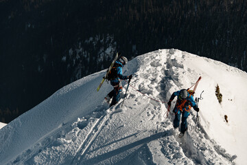 high angle view of men skiers with backpacks and ski equipment walking on snowy ridge