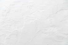The Tecture Of A Plastered Wall Whitewashed With A Fringe. Gray Background. Fragment Of A Gray Wall With Rough Strokes Of Whitewash.