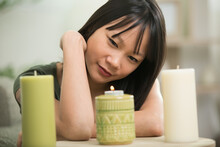 Woman Relaxing In The Home With Atmospheric Candles