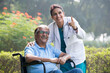 © G-images - Female doctor with old man in wheelchair admiring view at park