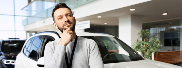 Wall Mural - middle-aged man thinking about buying a new car