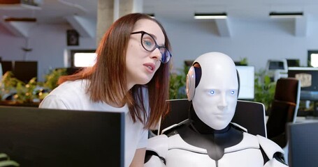 Wall Mural - Close up of robot and woman cooperating. Woman talking, helping. Android working at computer in coworking space with female. Humanoid as IT worker. Futuristic communication. Artificial intelligence