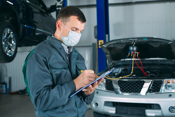 Wall Mural - mechanic maintaining car record on clipboard at the repair shop.