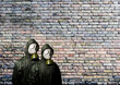 Gas masks. Two people with gas masks and brick wall behind with copy space..