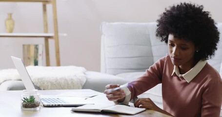 Poster - Running her own home based business like a boss. 4k footage of an attractive young woman using a laptop and making notes while working at home.