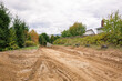 Road construction. Sand mounds and leveled land. Driveways. Creation of infrastructure. Nature landscape. Summer. Rural country road. Close-up. Copy space. Nobody. No people. Earthwork. Sand quarry