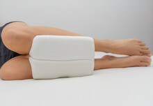 Young Woman Lying In Bed With Sleep Support Pillow