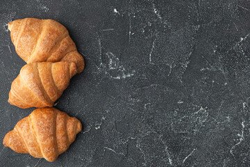 Wall Mural - Close up shot of a bunch of homemade croissants on a dark background.