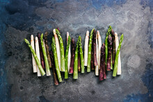 Green, White And Purple Asparagus On A Kitchen Background