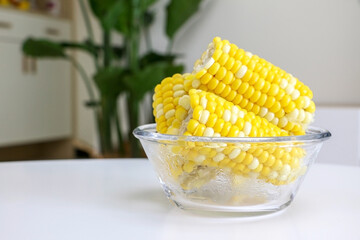 Wall Mural - A glass bowl of corn on the cob (sweet corn, maize) on table in the living room, healthy food concept