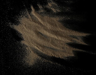 Wall Mural - Sand pile isolated on black background, top view