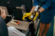 Stewardess in gloves giving champagne to woman in airplane