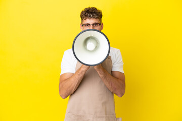 Poster - Restaurant waiter blonde man isolated on yellow background shouting through a megaphone