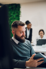 Wall Mural - Handsome businessman sitting at his desk in the office