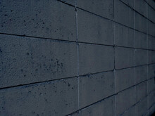 劣化してひび割れているコンクリートブロックの壁の暗い青色のグラフィク写真素材