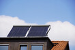 Solarthermie Anlage auf einer Dachgaube. Die Panele sind schräg gestellt um noch mehr Sonnenenergie aufnehmen zu können. DEr blaue Himmel mit einigen Schönwetter Wolken verspricht eine hohe Ausbeute