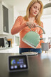 Smart Energy Meter In Kitchen Measuring Electricity And Gas Use With Woman Boiling Kettle