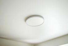 Round, Minimalist, Simple Lamp On A White Ceiling. A Lamp That Does Not Attract Attention.