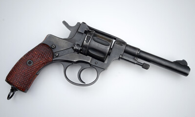 Photo of a revolver of the nagant system on a white background.A metal pistol on a white isolate.