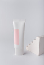 Cream Tube With Pink Blank Label, No Brand Mockup On White Background With Geometric Concrete Decor. Tender Minimal Composition