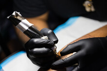 Hands Of Tattoo Artist In Black Gloves Busy With Work.