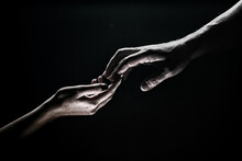Two Hands. Helping Hand To A Friend. Rescue Or Helping Gesture Of Hands. Concept Of Salvation. Hands Of Two People At The Time Of Rescue, Help. Isolated On Black Background. Tenderness, Tendet Touch.
