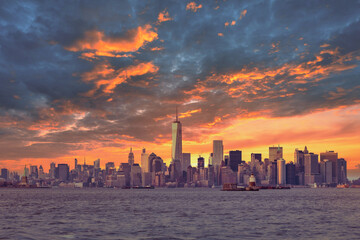 Fototapete - New York City Manhattan downtown skyline at dusk with skyscrapers illuminated over Hudson River panorama. Dramatic sunset sky.