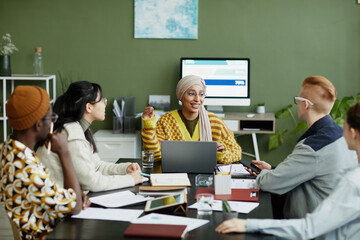 Wall Mural - Portrait of ethnic female manager talking to creative team in business meeting at modern office