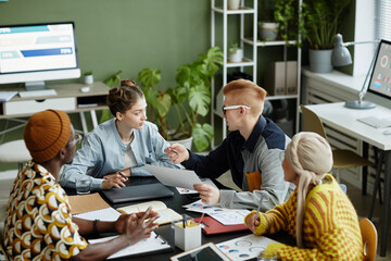 Wall Mural - Diverse creative team collaborating in business meeting and enjoying work on project together, high angle