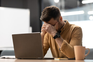 Wall Mural - Desperate Businessman Near Laptop Covering Face Having Problem In Office