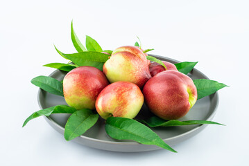 Wall Mural - A plate of fresh nectarines on a white background