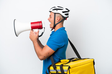 Wall Mural - Young caucasian man with thermal backpack isolated on white background shouting through a megaphone