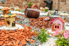 Garden Arrangement With Wood Logs, Wicker Baskets, Gravel And Various Ornaments