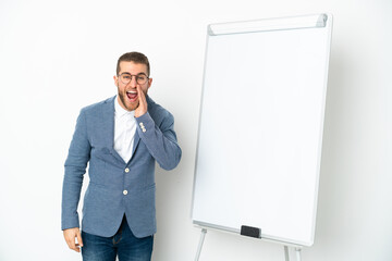 Young business woman giving a presentation on white board isolated on white background shouting with mouth wide open